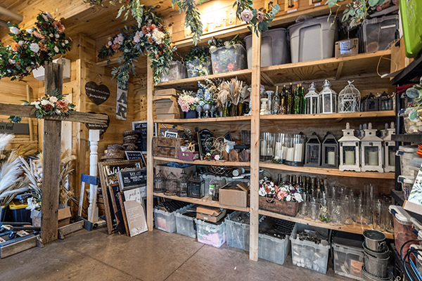 Huge library of wedding reception decor on shelves, hanging and in storage bins